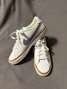 Nike Women's White Leather Sneakers with Blue Swoosh and Gold Accent